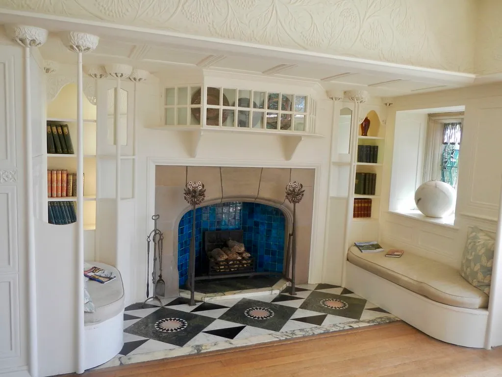 Fireplace with a cobalt-blue tile surround and a black-and-white marble inlaid hearth