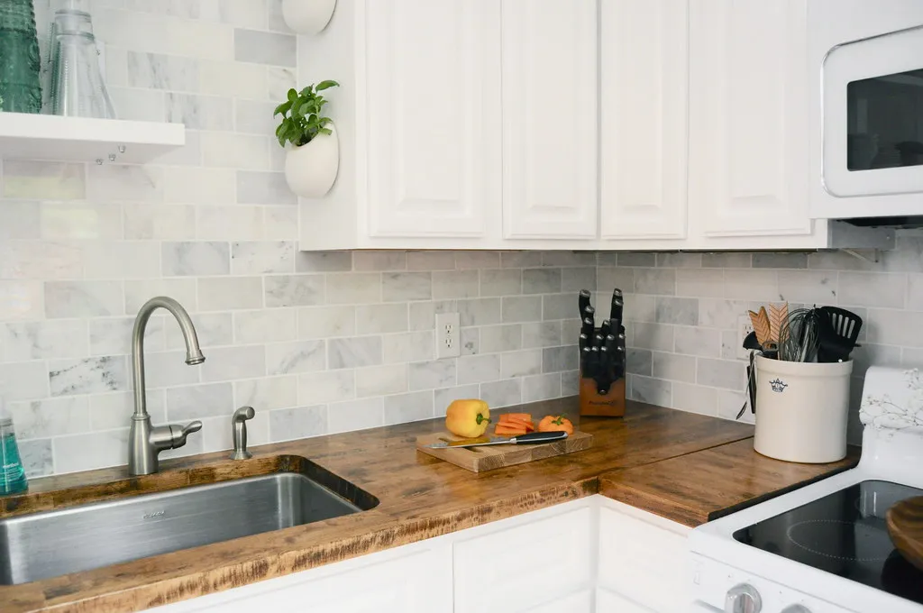 Custom marble subway tile backsplash above butcher-block counters