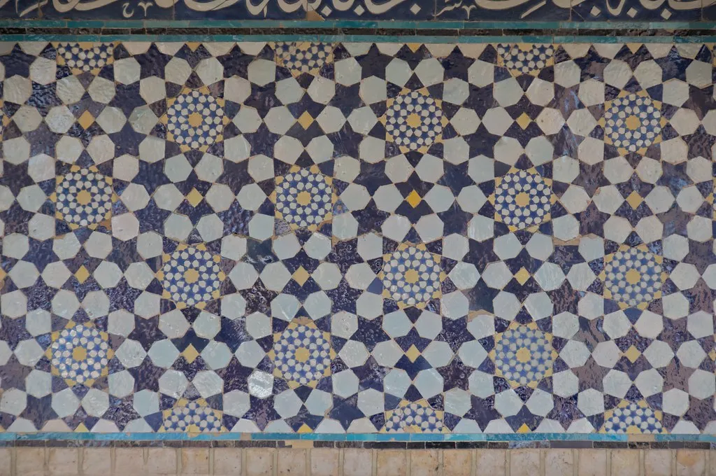 Geometric blue and gold mosaic tile wall in a star-and-polygon pattern