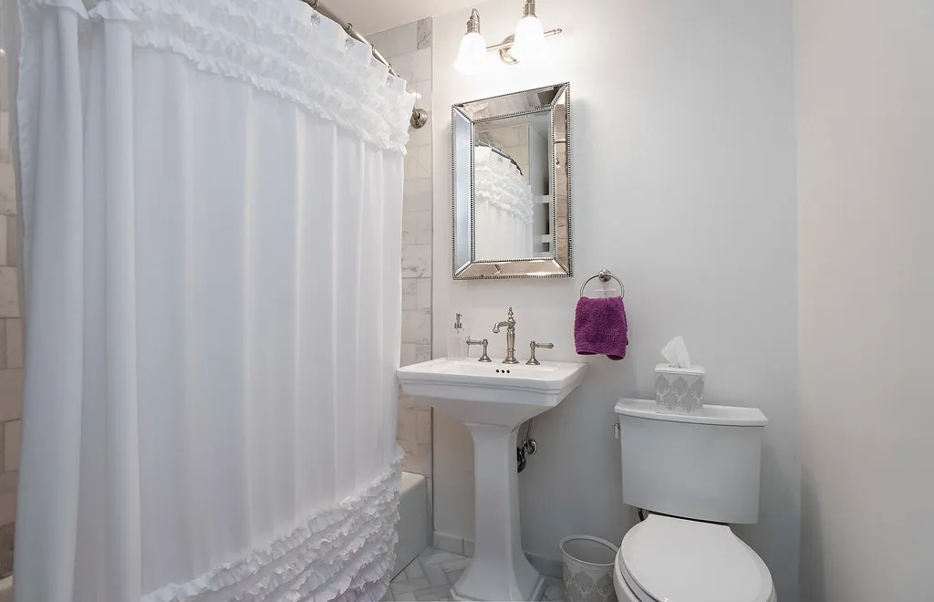 Renovated bathroom with marble tile shower surround and marble mosaic floor