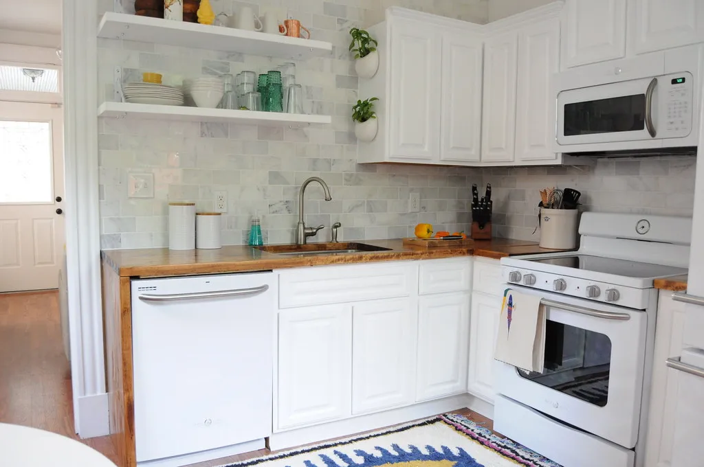 Bright kitchen with a marble subway tile backsplash and open shelving