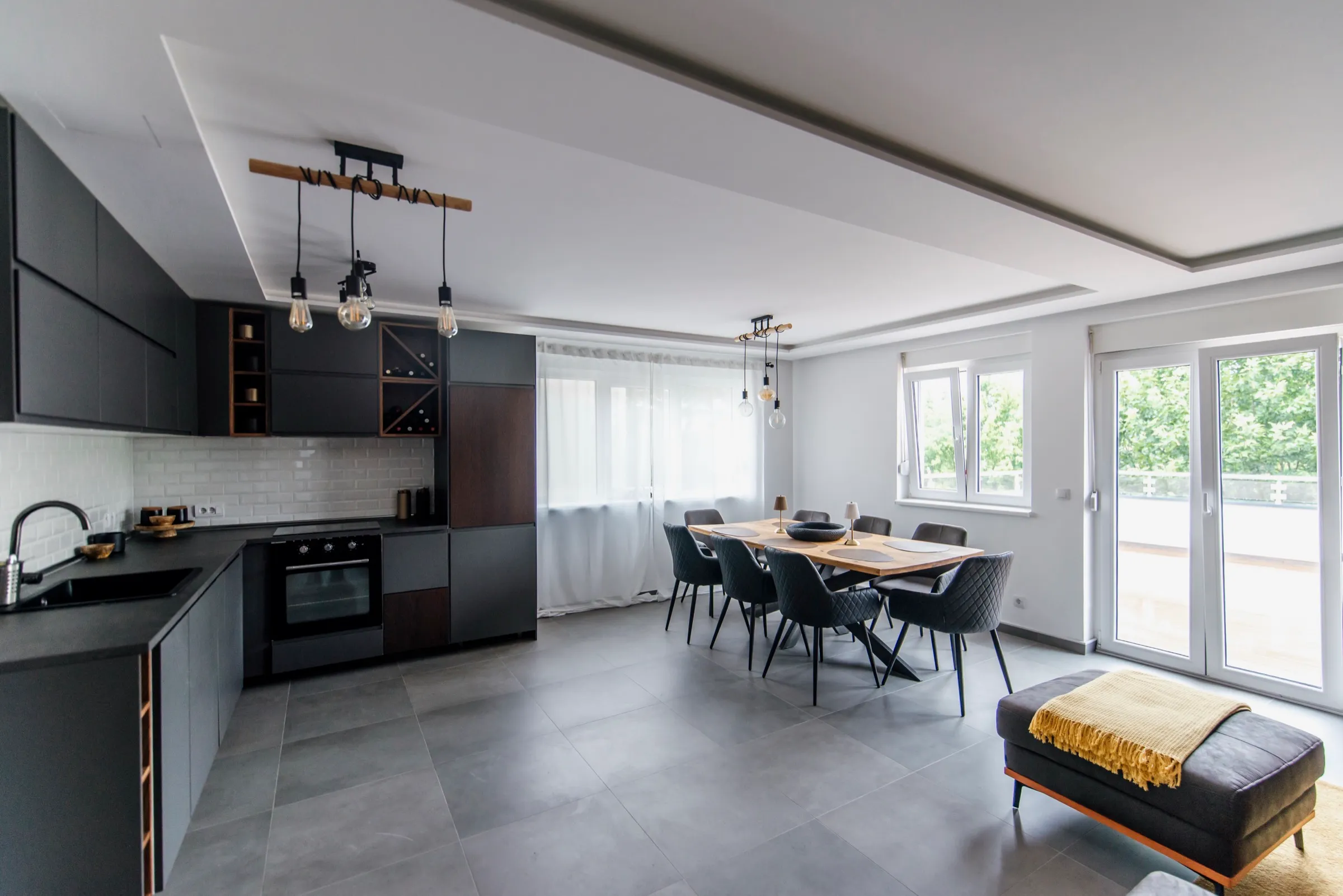 Open-plan kitchen and dining room with large-format gray porcelain floor tile