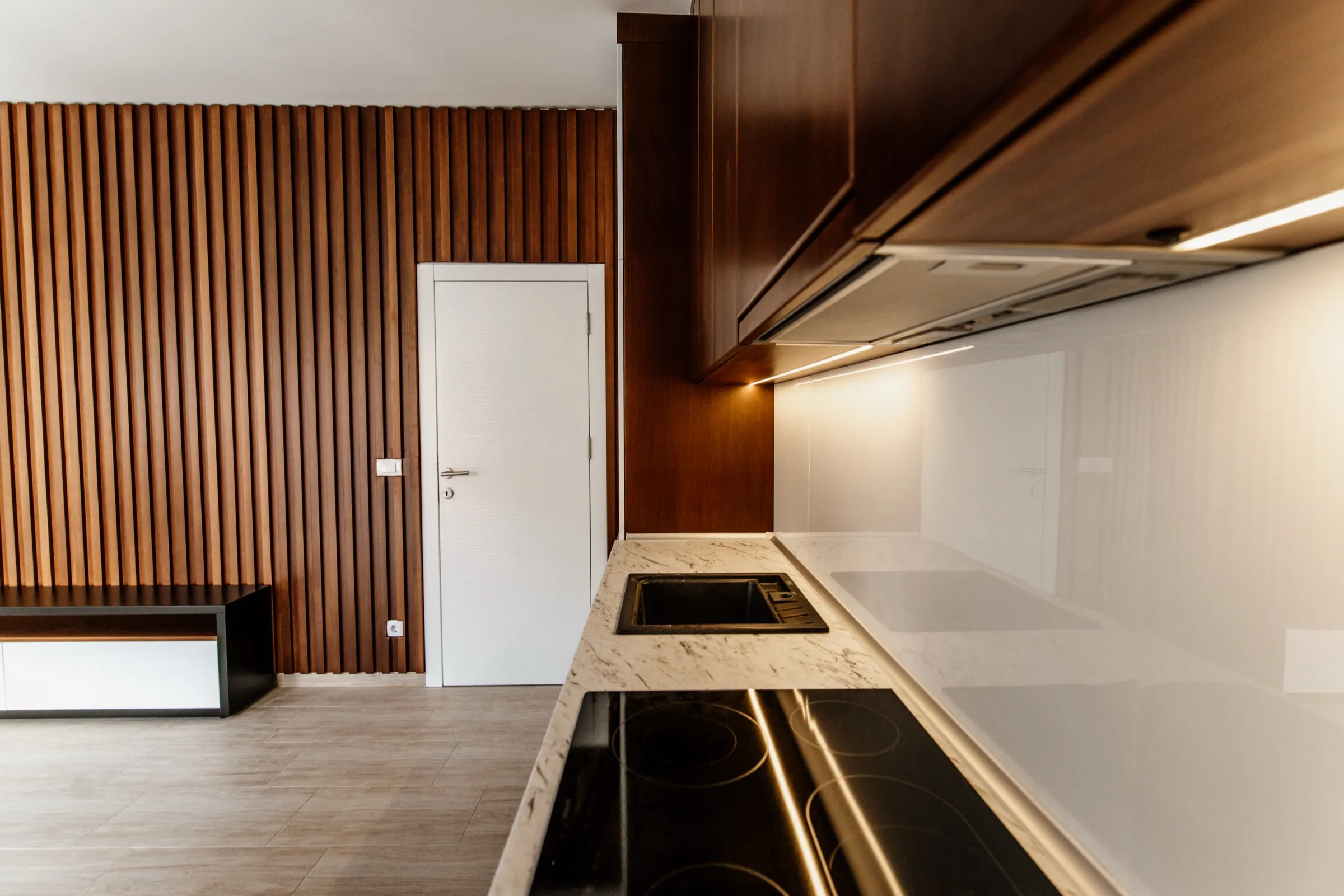 Modern kitchen with a marble countertop and wood-look porcelain plank flooring