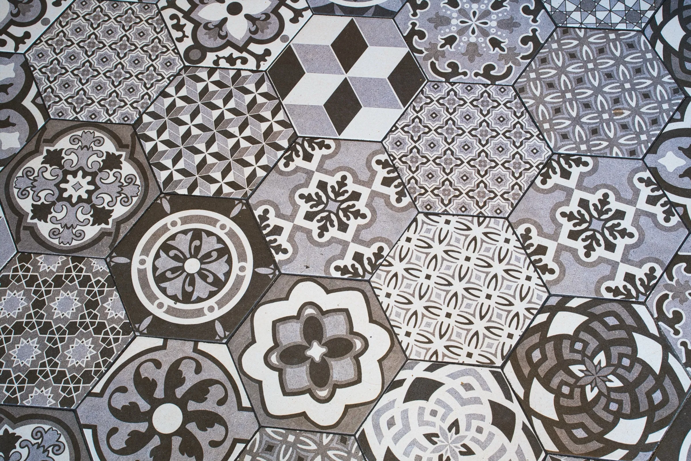 Patterned encaustic-style hexagonal cement floor tiles in gray and white